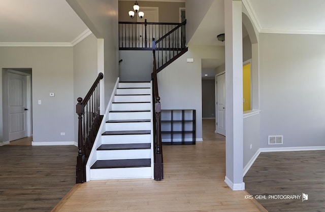 13464 W Hidden Springs Trl, Wadsworth, IL 60083 - staircase featuring an inviting chandelier, wood finished floors, crown molding, visible vents, and baseboards