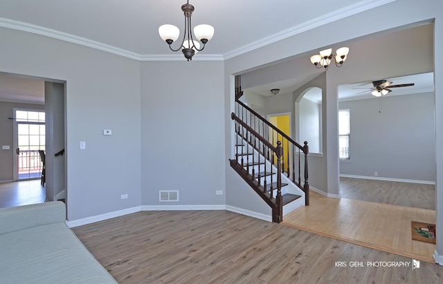 13464 W Hidden Springs Trl, Wadsworth, IL 60083 - unfurnished living room featuring a wealth of natural light, visible vents, ceiling fan with notable chandelier, wood finished floors, and arched walkways