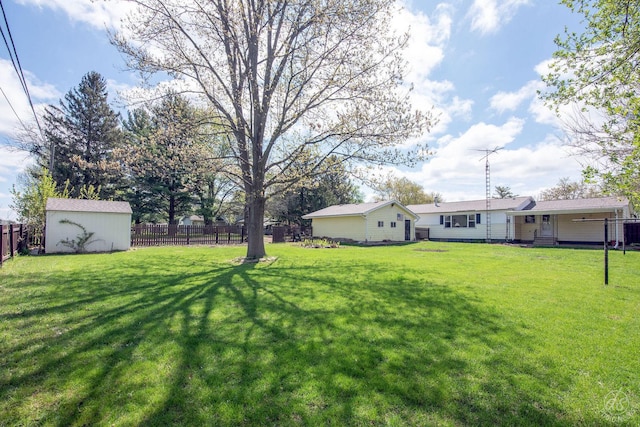view of yard with an outdoor structure, a fenced backyard, and a storage unit