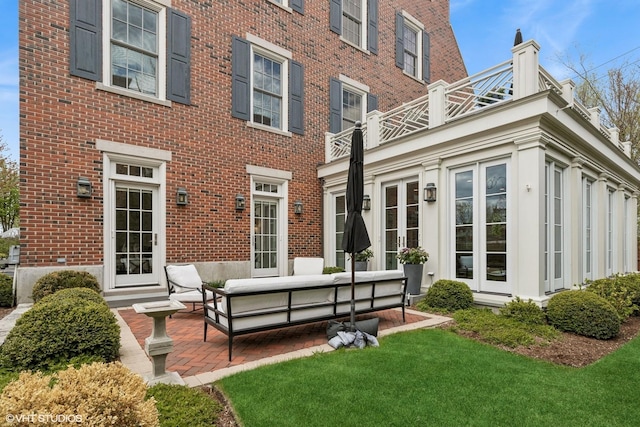847 N Mckinley Rd, Lake Forest, IL 60045 - back of property featuring brick siding, french doors, outdoor lounge area, a patio area, and a lawn
