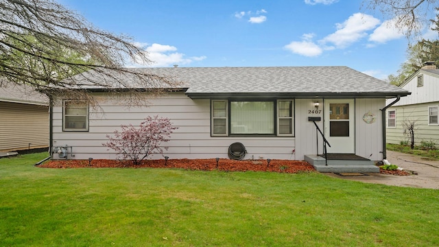 ranch-style house with a shingled roof and a front yard