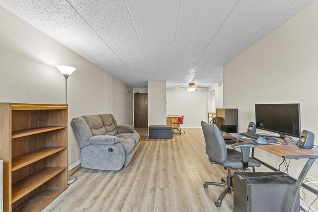 home office with a textured ceiling, baseboards, a ceiling fan, and wood finished floors