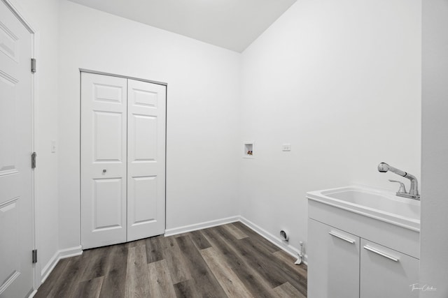 clothes washing area with dark wood-style flooring, hookup for a washing machine, cabinet space, and baseboards