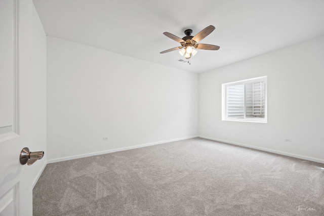 carpeted empty room with ceiling fan and baseboards