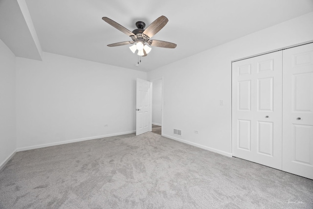 unfurnished bedroom featuring carpet, baseboards, a closet, and ceiling fan