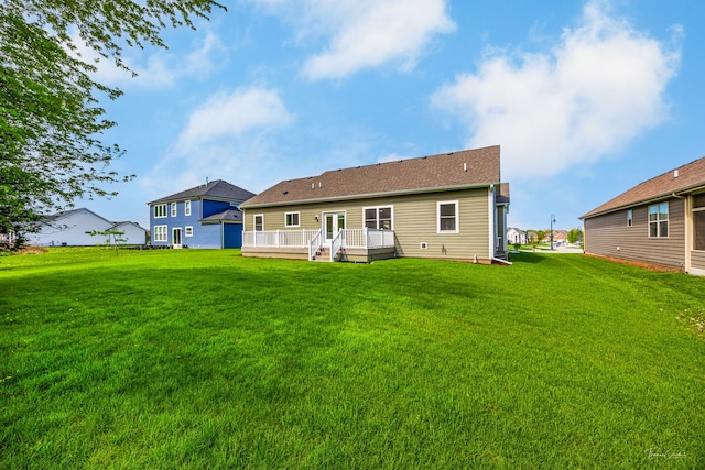 back of property with a deck and a yard