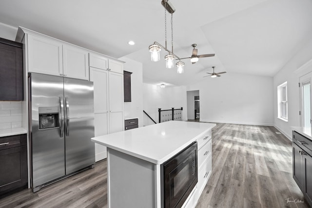 kitchen with stainless steel refrigerator with ice dispenser, black microwave, vaulted ceiling, ceiling fan, and light countertops