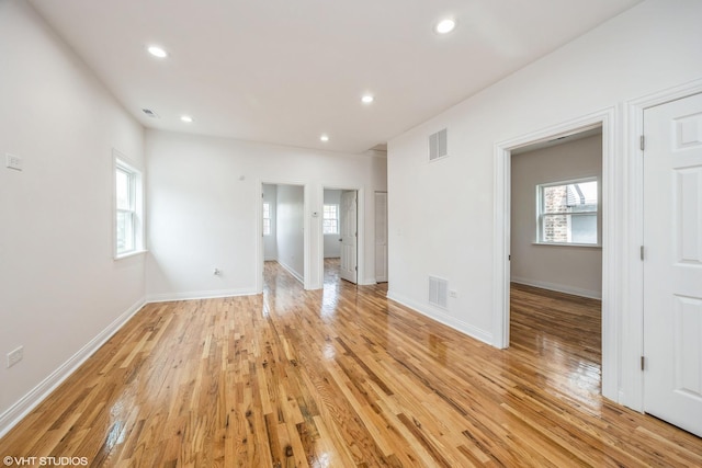 spare room featuring a wealth of natural light, light wood-style flooring, and visible vents