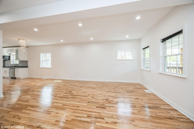 unfurnished living room featuring recessed lighting, baseboards, visible vents, a sink, and light wood-style floors