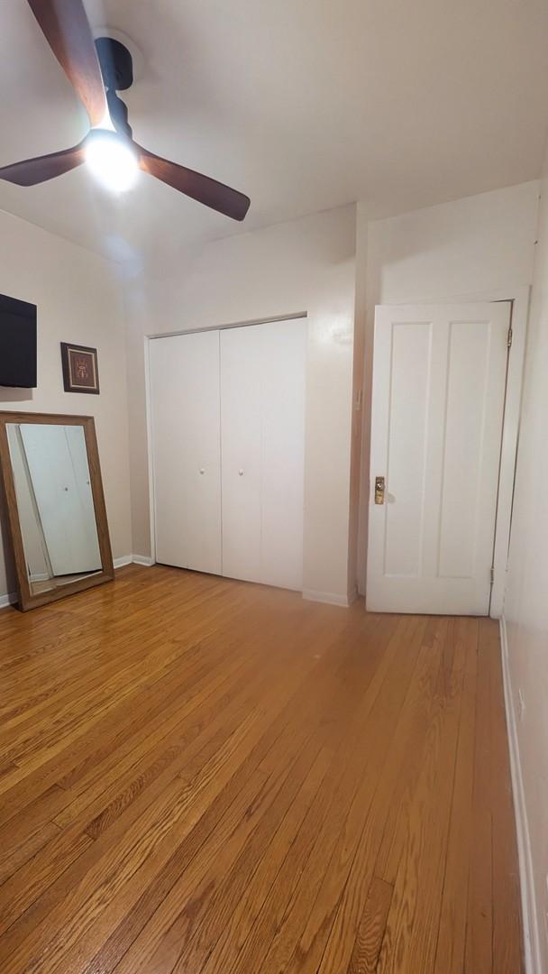 unfurnished bedroom with baseboards, ceiling fan, a closet, and light wood-type flooring