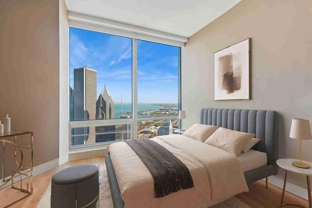 401 N Wabash Ave Unit 57F, Chicago, IL 60611 - bedroom with a wall of windows, a water view, baseboards, and wood finished floors