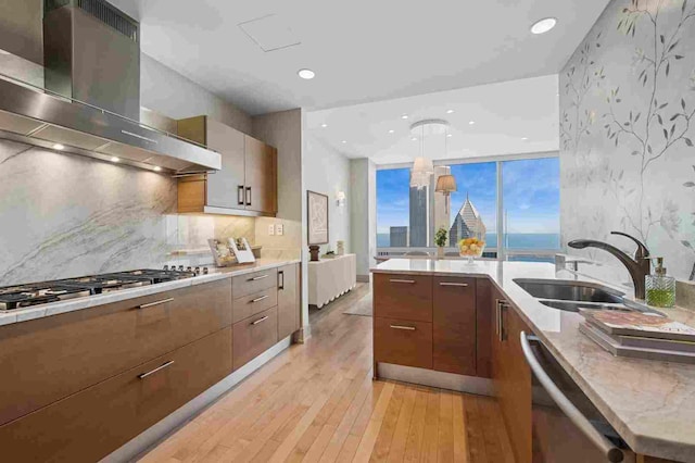 401 N Wabash Ave Unit 57F, Chicago, IL 60611 - kitchen featuring appliances with stainless steel finishes, light wood-type flooring, a sink, wallpapered walls, and extractor fan