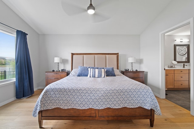 bedroom with light wood finished floors, ceiling fan, ensuite bathroom, and baseboards