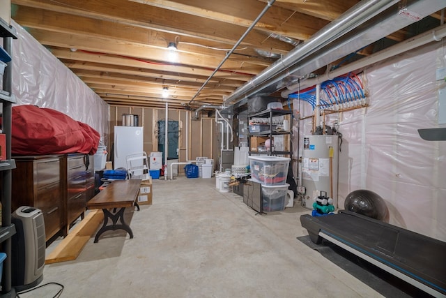 unfinished basement with water heater and freestanding refrigerator