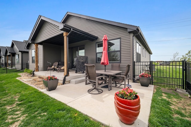 back of house featuring a patio, fence, a lawn, and outdoor dining space