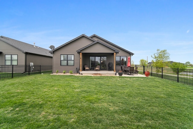 rear view of house featuring a yard, a patio, and a fenced backyard