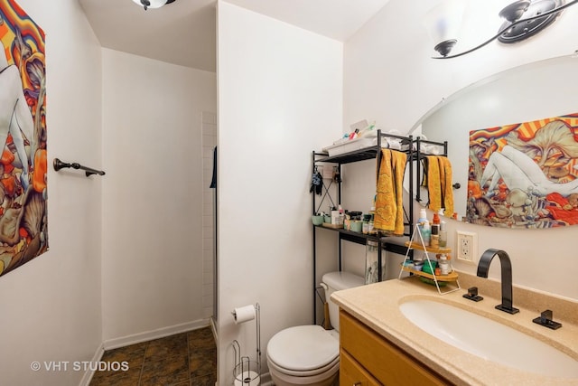 bathroom with vanity, toilet, and baseboards