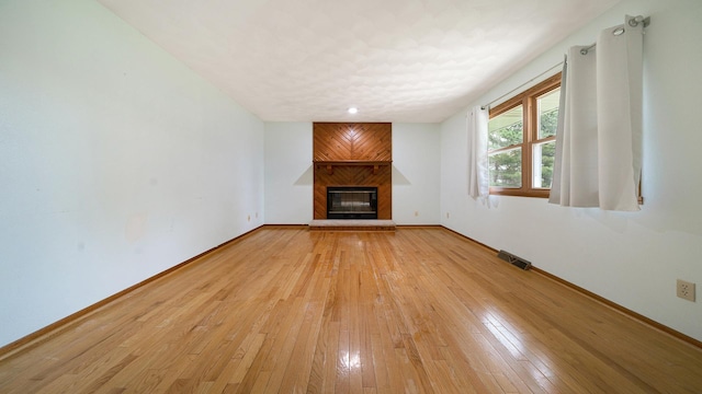 4401 Windsor Ct, Loves Park, IL 61111 - unfurnished living room featuring baseboards, light wood-type flooring, visible vents, and a large fireplace