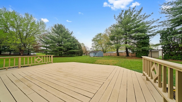 4401 Windsor Ct, Loves Park, IL 61111 - deck featuring a storage unit, a lawn, fence, and an outbuilding