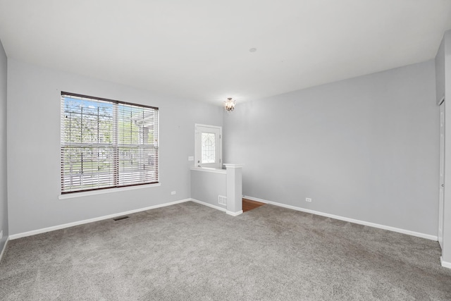 spare room with visible vents, baseboards, and carpet floors