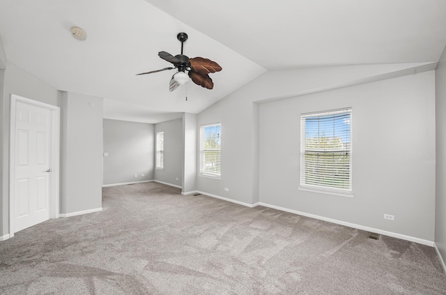 spare room with carpet flooring, a ceiling fan, visible vents, baseboards, and lofted ceiling