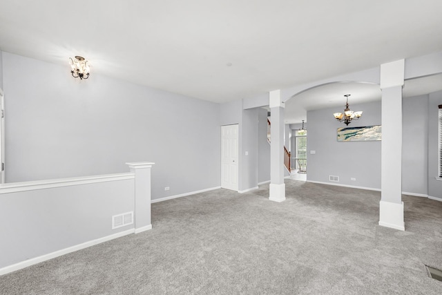 unfurnished living room featuring a chandelier, carpet flooring, baseboards, and visible vents