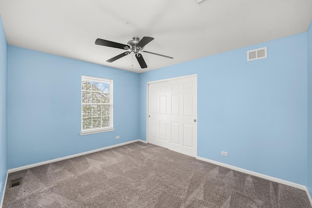 unfurnished bedroom featuring baseboards, a closet, visible vents, and carpet floors
