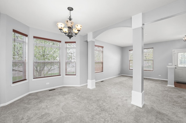 unfurnished dining area with arched walkways, carpet flooring, a chandelier, and visible vents