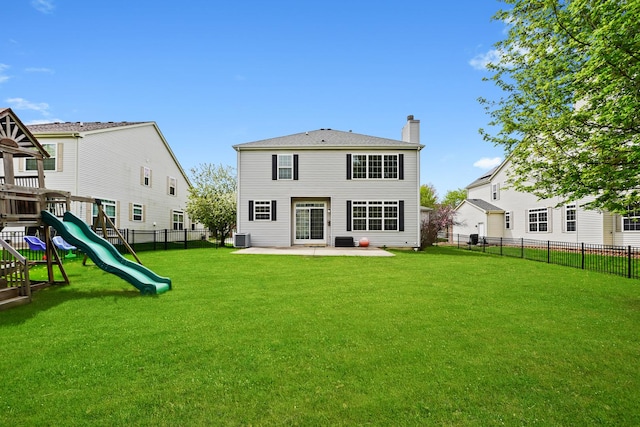 back of house featuring a chimney, central air condition unit, a fenced backyard, and a lawn