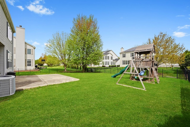 view of yard featuring a fenced backyard, a patio area, central AC, and a playground