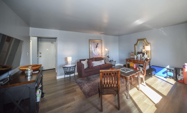 living area with baseboards and wood finished floors