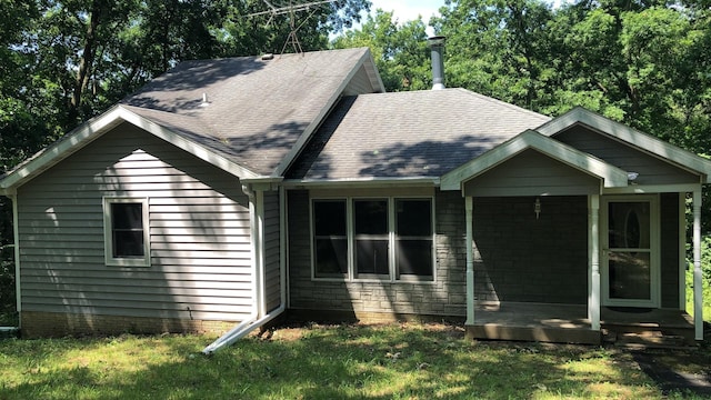 exterior space with a lawn and a shingled roof