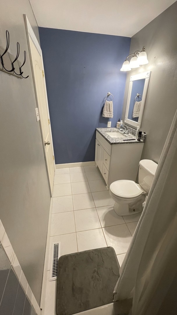 bathroom featuring visible vents, tile patterned floors, baseboards, vanity, and toilet