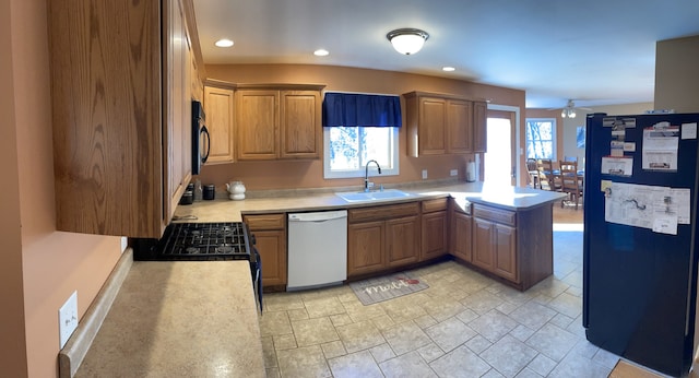 kitchen with ceiling fan, a sink, light countertops, a peninsula, and black appliances
