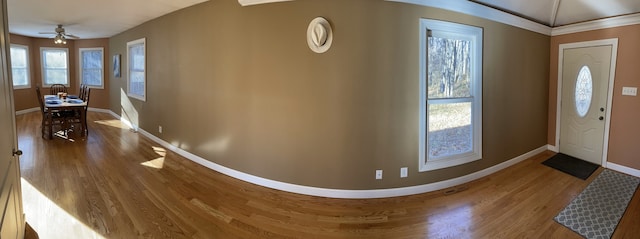 foyer entrance with baseboards, ceiling fan, and wood finished floors