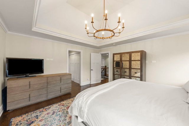 bedroom featuring a closet, ornamental molding, a raised ceiling, a chandelier, and dark wood finished floors