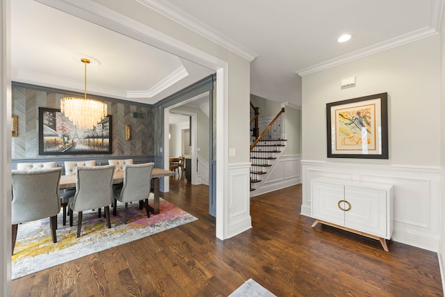 dining space featuring crown molding, dark wood finished floors, stairs, and a chandelier
