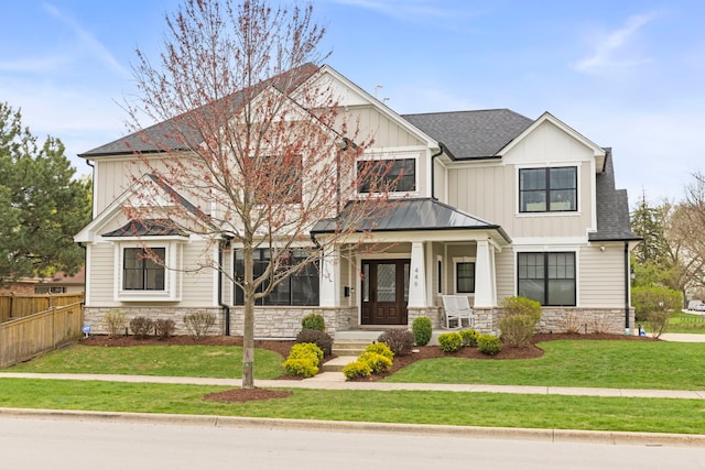 craftsman-style house featuring fence, roof with shingles, a front lawn, and stone siding