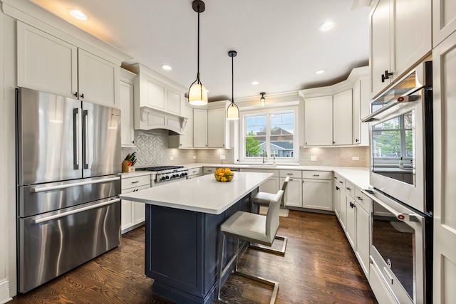 kitchen featuring light countertops, stainless steel appliances, dark wood finished floors, and plenty of natural light