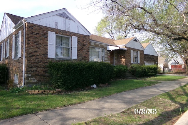 bungalow-style home with a front yard and brick siding