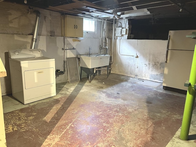 basement with washer / clothes dryer, a sink, and freestanding refrigerator