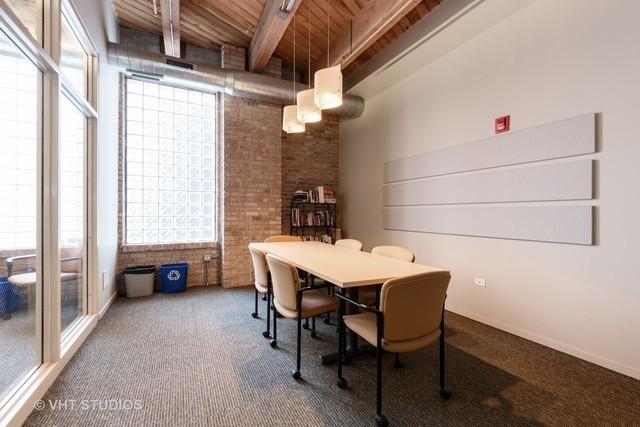1040 W Adams St Unit 203, Chicago, IL 60607 - dining space with wood ceiling with exposed beams, brick wall, and carpet flooring