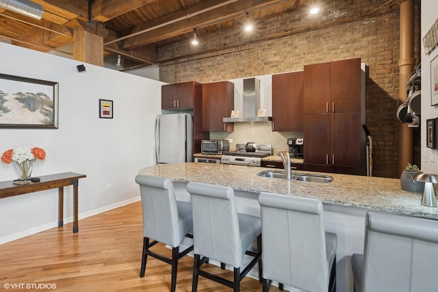 1040 W Adams St Unit 203, Chicago, IL 60607 - kitchen featuring wall chimney range hood, a sink, freestanding refrigerator, range, and a towering ceiling
