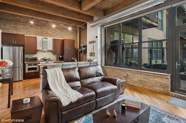 1040 W Adams St Unit 203, Chicago, IL 60607 - living room with brick wall, light wood-type flooring, beam ceiling, and a towering ceiling