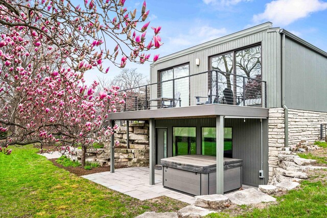 221 Parkview Dr, Bloomington, IL 61701 - back of property featuring a hot tub, a balcony, a patio area, and stone siding