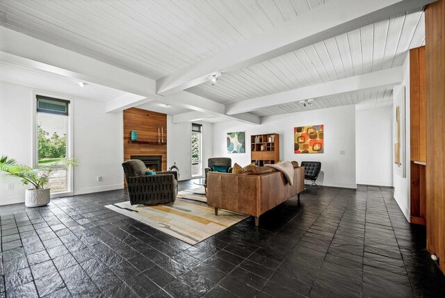 221 Parkview Dr, Bloomington, IL 61701 - living room featuring baseboards, beam ceiling, stone tile flooring, and a fireplace