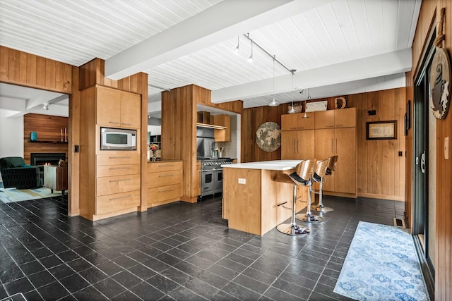 221 Parkview Dr, Bloomington, IL 61701 - kitchen featuring wood walls, built in microwave, beam ceiling, a kitchen breakfast bar, and double oven range