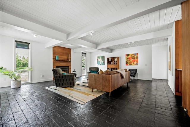 221 Parkview Dr, Bloomington, IL 61701 - living room featuring baseboards, beamed ceiling, stone tile flooring, and a large fireplace
