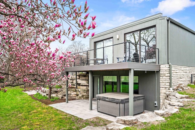 221 Parkview Dr, Bloomington, IL 61701 - rear view of property with a hot tub, a balcony, a patio, and stone siding