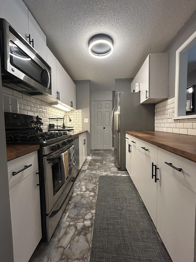 1216 S New Wilke Rd Unit 106, Arlington Heights, IL 60005 - kitchen featuring a textured ceiling, decorative backsplash, stainless steel appliances, and butcher block counters